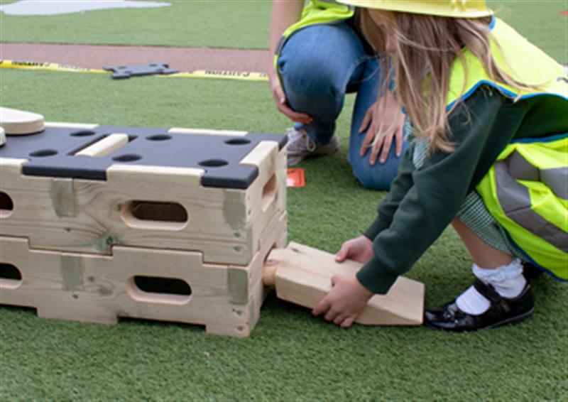 Image of a child who has stacked up blocks of Play Builder and slotting in an Entry Plank